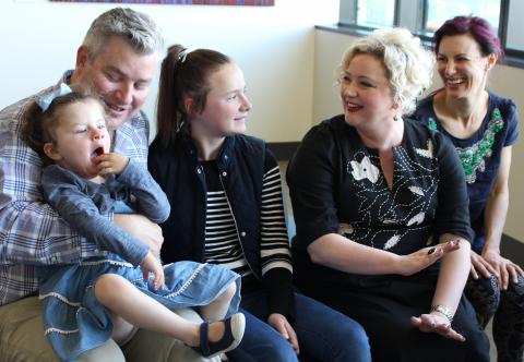 Minister Hennessy with child patient Ginger and her family